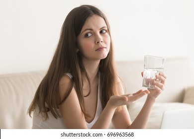 Doubtful Young Woman Feels Unsure Taking Medicine, Depressed Unhealthy Girl Holding Antidepressant Pill, Glass Of Water At Home, Making Decision Of Emergency Contraceptive, Worried About Side Effects