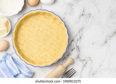 Dough for baking quiche tart pie in ceramic form. Culinary concept. Flat lay. Сopy space - Shutterstock ID 1989813275