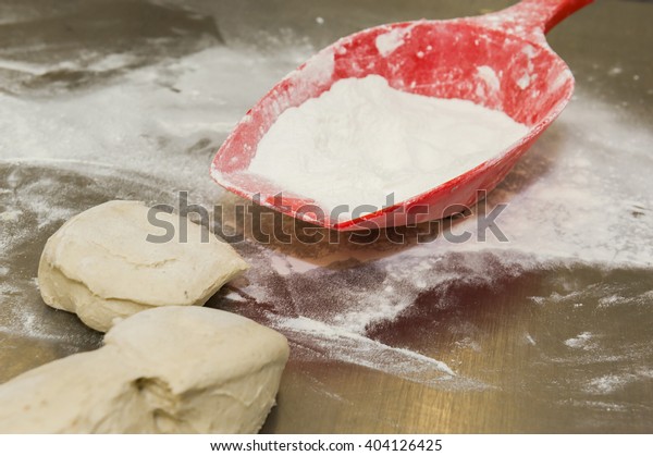 Dough balls and red scoop\
with flour.