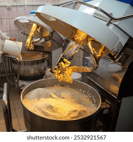 Dough is being mixed in large containers as skilled workers prepare for the biscuit production process in a busy factory setting. - Powered by Shutterstock