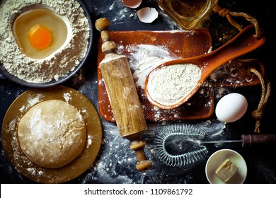 Dough, flour with accessories for the kitchen in the composition on the kitchen table