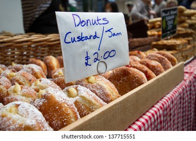 Doughnuts with custard and jam for sale at food market.