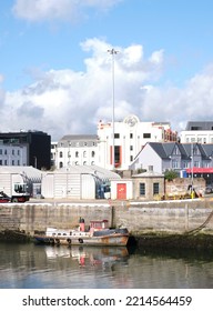 Douglas, Isle Of Man, UK
September 23  2022
An Old, Rusting Boat Moored In Douglas Harbour, Isle Of Man With The Elegant Royalty House Building In The Distance.