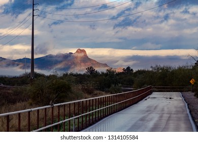 Dove Mountain Shrouded In Fog On An Overcast Morning Along The Loop A Biking, Jogging And Running Path In Tucson, Arizona. Wet Pavement, Fence, Utility Lines And Curves Ahead. January Of 2019.