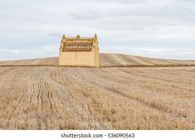 Dovecote and harvested cereal fields.