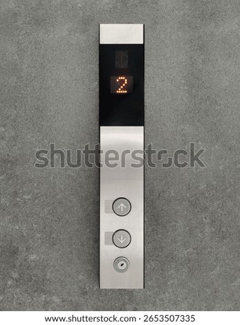 Up and down elevator buttons on the cement wall.