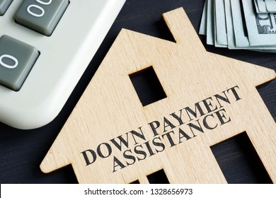 Down Payment Assistance Written On A Model Of Home.
