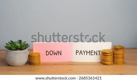 Down payment concept. Initial upfront payment made when buying a house, car, or expensive item, reducing the amount that must be financed or borrowed. Notebook with inscription and coins