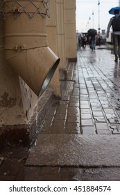 the down pipe on the facade of the house in the city in the rain with vandal-proof mesh
