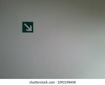 Down pointing arrow in the left upper corner of the frame on a grey background pointing towards empty blank copy space