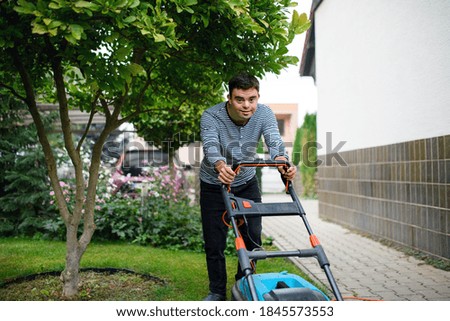 Similar – Young man mowing the lawn with lawnmower