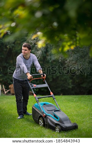 Similar – Young man mowing the lawn with lawnmower