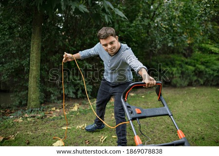 Similar – Young man mowing the lawn with lawnmower