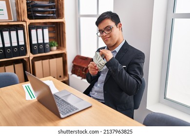 Down syndrome man business worker using laptop counting dollars at office