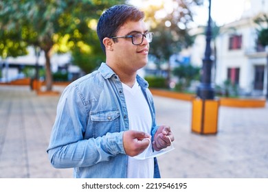 Down Syndrome Man Smiling Confident Holding Medical Mask At Park