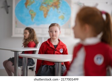 Down syndrome schoolgirl paing attention in class at school, integration concept. - Powered by Shutterstock