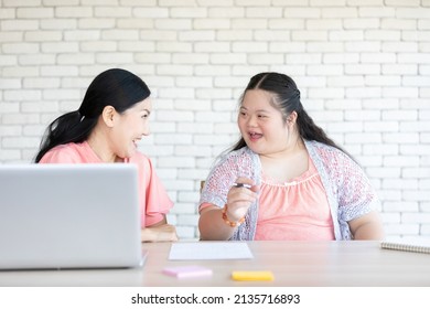 down syndrome teenage girl and her teacher talking together on a table