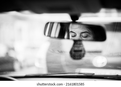 Downcast Female Eyes In The Rearview Mirror