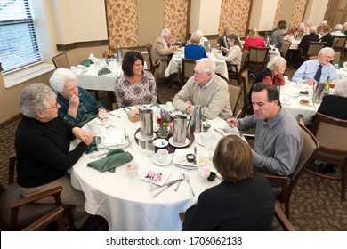 DOWNERS GROVE, ILLINOIS / USA - NOVEMBER 12, 2017: Family enjoying a meal together in a senior's community dining room. 
