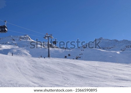 Downhill skiers in Hochgurgl ski resort on a beautiful sunny day, perfect conditions for winter sport, skiing and snowboarding in the snow capped alpine mountains in the Ötztal valley, Tyrol, Austria.