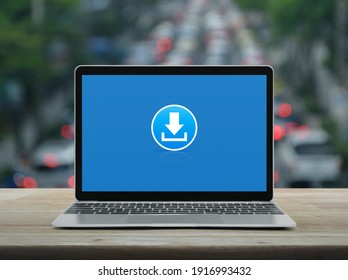 Download flat icon with modern laptop computer on wooden table over blur of rush hour with cars and road in city, Technology internet online concept - Shutterstock ID 1916993432