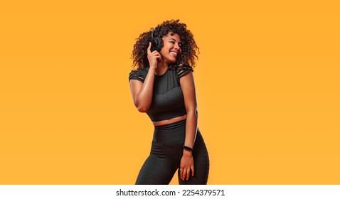 Download high resolution photo for advertising and promotion of electronics shop or fitness club in social networks. African american woman isolated on yellow background. Copy Space.