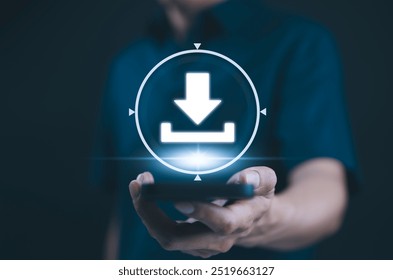 Download Technology for Data Storage and Transfer. A person holds smartphone with glowing download icon, symbolizing digital data storage, cloud services, technology for transferring files and media. - Powered by Shutterstock