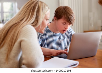 Downs Syndrome Man Sitting With Home Tutor Using Laptop For Lesson At Home - Shutterstock ID 1400017193