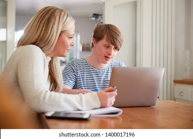 Downs Syndrome Man Sitting With Home Tutor Using Laptop For Lesson At Home - Shutterstock ID 1400017196