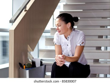 Downsizing, sad business woman Sitting on Stairs