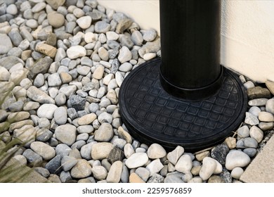Downspout, Drainage stone Pebble around House, Outdoor close up. French Drain. Sewage pipe, Downpipe, Waterspout rainwater.