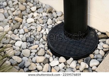 Downspout, Drainage stone Pebble around House, Outdoor close up. French Drain. Sewage pipe, Downpipe, Waterspout rainwater.