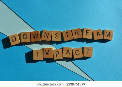Downstream Impact, business buzzword phrase in wooden alphabet letters isolated on blue background