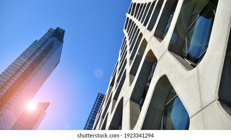 Die Architektur des Geschäftsviertels im Stadtzentrum. Glasreflektierende Bürogebäude auf blauem Himmel und Sonnenlicht. Wirtschaft, Finanzen, Business Activity Konzept. Steigende Sonne am Horizont.