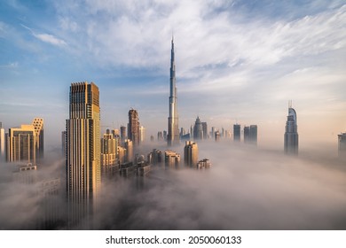 Downtown Dubai with skyscrapers submerged in think fog. Picture taken from unique view. Tall buildings. Early morning glow.  - Shutterstock ID 2050060133