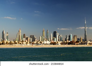 Downtown of Dubai (UAE) in the evening. Burj Khalifa, the tallest building in the world. Beautiful skyline of modern skyscrapers of  city built in the desert.  The view from the beach of Persian Gulf.
