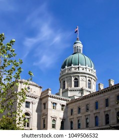 Downtown Indianapolis, Indiana State Capital Building On A Blue Sunny Day With American Flag Flying.