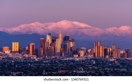 Downtown Los Angeles Skyline With Snow Capped Mountains Behind At Twilight