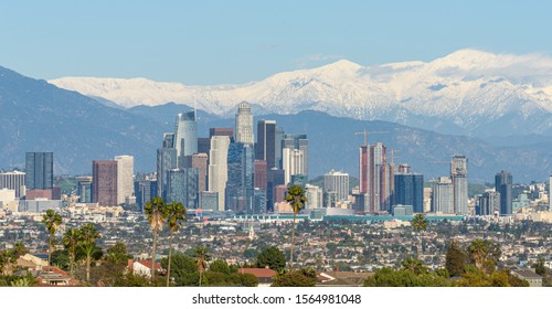 Downtown Los Angeles Skyline With Snow Capped Mountains Behind At Sunny Day