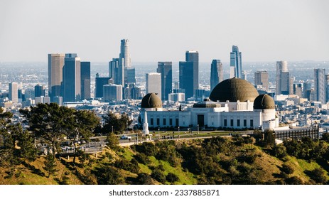 From downtown Los Angeles, the view over Griffith Observatory showcases an enchanting cityscape that dazzles with its twinkling lights against the night sky, offering a captivating blend of urban char - Powered by Shutterstock