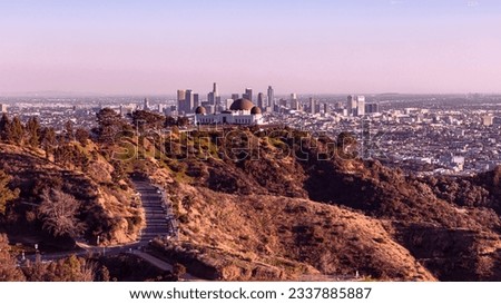 From downtown Los Angeles, the view over Griffith Observatory showcases an enchanting cityscape that dazzles with its twinkling lights against the night sky, offering a captivating blend of urban char