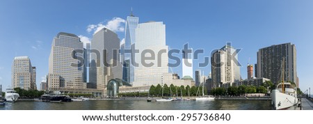 Downtown Manhattan New York City skyline featuring modern office towers under bright blue sky panorama