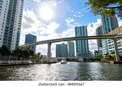 Downtown Miami along the Miami River inlet with Brickell Key in the background and yacht cruising ander the bridge