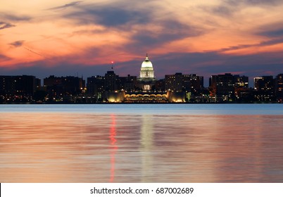 Downtown skyline of Madison, the capital city of Wisconsin,USA.After sunset view  with State Capitol building dome against beautiful bright sky and reflection in lake water as seen across lake Monona.