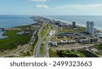 Downtown South Padre Island along Padre Boulevard, State Park Road 100 from Isla Blanca Beach, high-rise condos, beach-front hotels, white sandy beaches turquoise water, calm waves, aerial view. USA