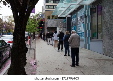 DOWNTOWN VANCOUVER, BC, CANADA - APR 26, 2020: Customers In Downtown Vancouver Line Up And Wait To Get Into A Store Due To Capacity Restrictions In Light Of The Covid 19 Pandemic.