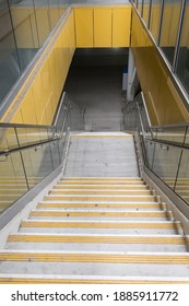 Downward angle of night time gritty yellow stair case lit with overhead light 