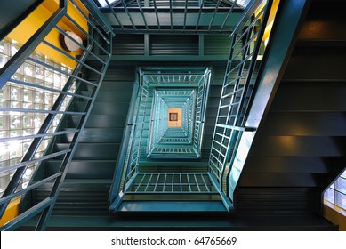 Downward green staircase with yellow and glass walls