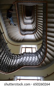 Downward spiralling staircase, guy at bottom