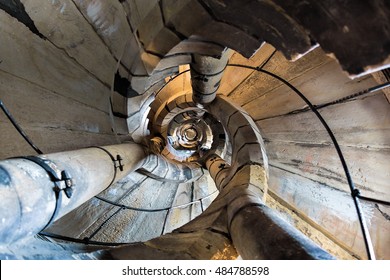 Downwards view of spiral stone stairs of old tower of gothic historic church.